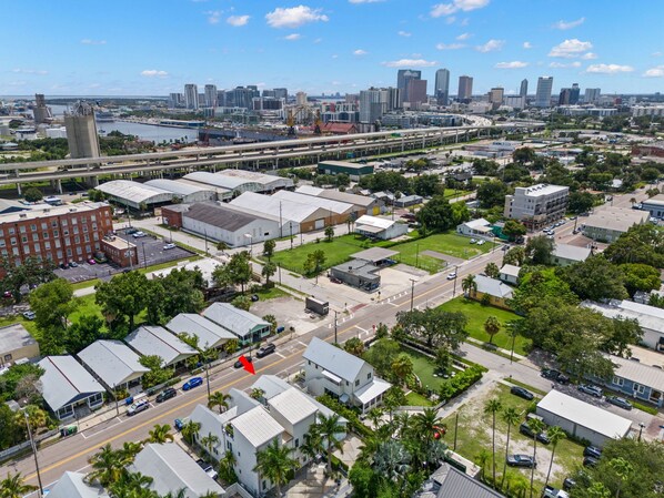 An aerial view of a cityscape with a mix of commercial and residential buildings, a prominent bridge, and a clear sky. - NEW Casa Fuente Ybor Bungalow Steps to 7th Ave (Tampa)