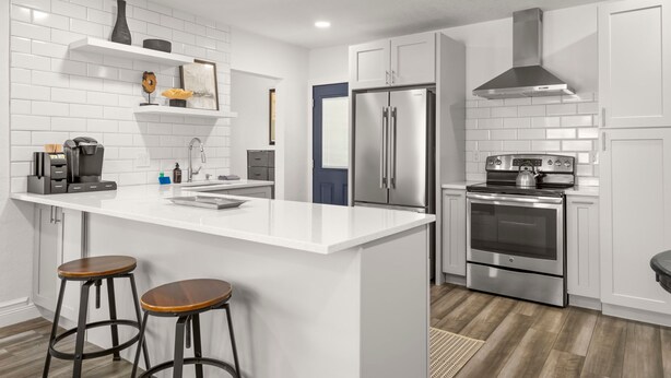A modern kitchen with white cabinetry, stainless steel appliances, a central island with stools, and a blue door. - NEW Soho Oasis - Stunning Home In Heart of Soho (Tampa)