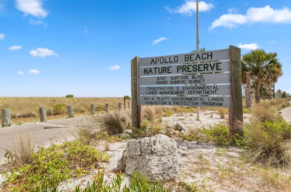 A sign for Apollo Beach Nature Preserve with contact information and hours of operation.
