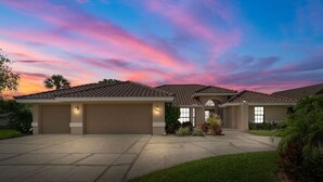 A residential house with a driveway, garage, and landscaped garden. - NEW Surfside Beach House Heated Pool Boat Dock (Apollo Beach)