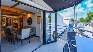 Un intérieur moderne comprenant un coin repas, un canapé et une porte vitrée donnant sur un balcon.