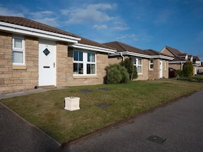 Houses with brick exteriors and pitched roofs line the street.