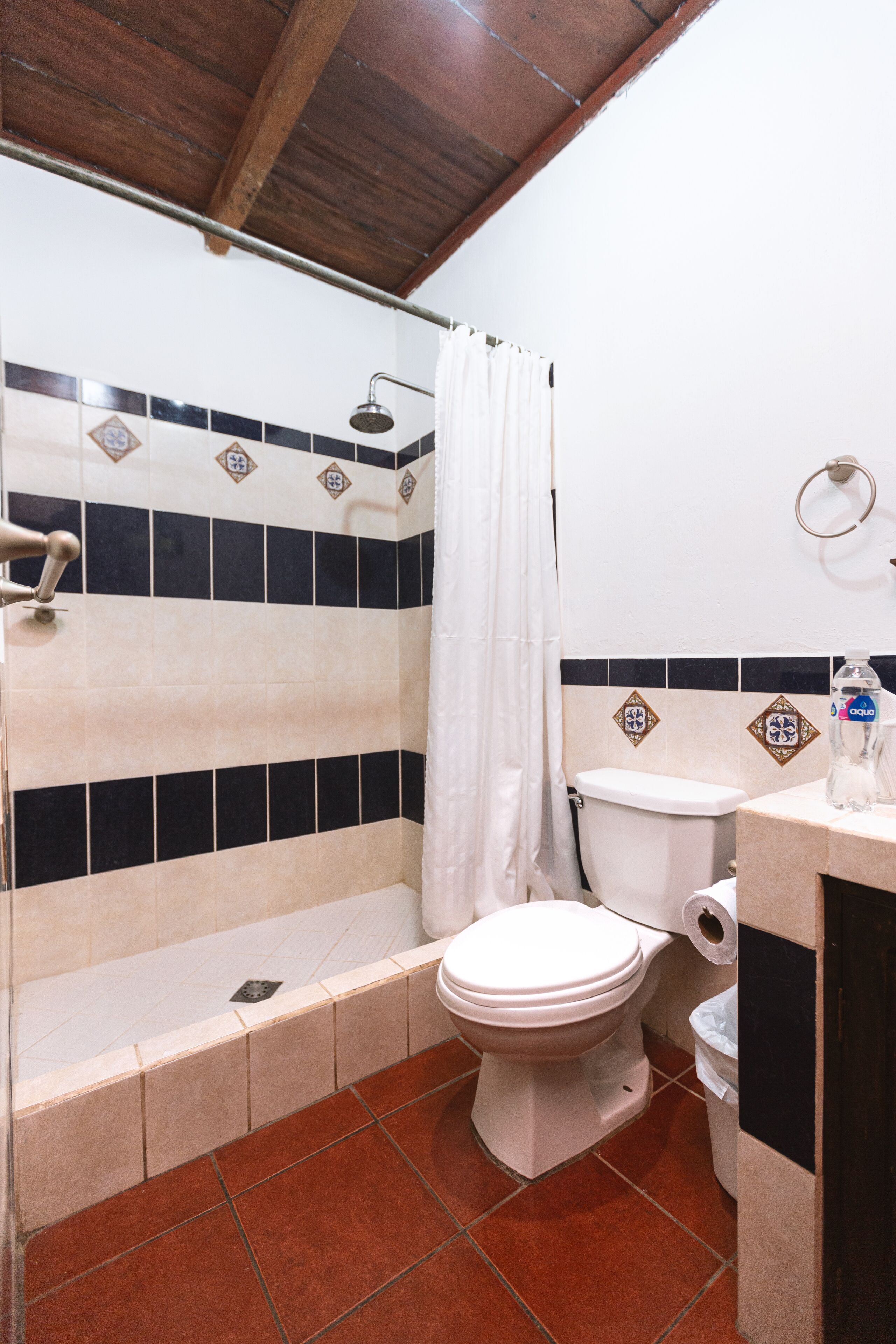 A bathroom with a shower, toilet, and sink.