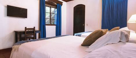 A bedroom with a large bed, a desk, and a chair.