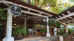 A covered outdoor seating area with a sign for 'Piura Restaurant / Café & Bar'. - Hotel Las Marias (Taxisco)