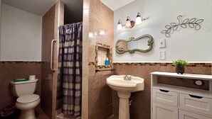 Ein Badezimmer mit Dusche, Toilette, Waschbecken und Waschtisch.