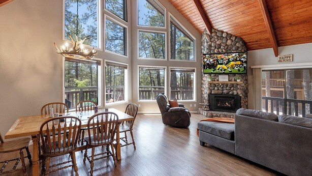 A spacious living room with a fireplace, large windows, and a cozy seating area.