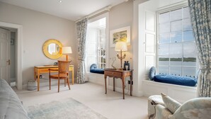 Een kamer met een bureau, stoel en een vensterbank met uitzicht op het water.