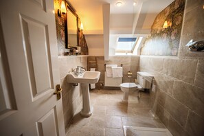 Baño con lavamanos, inodoro y ventana.
