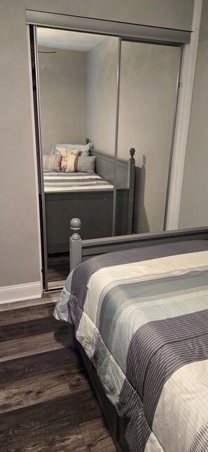 Relax in this serene bedroom with a comfortable bed and sliding glass door leading to a balcony.
