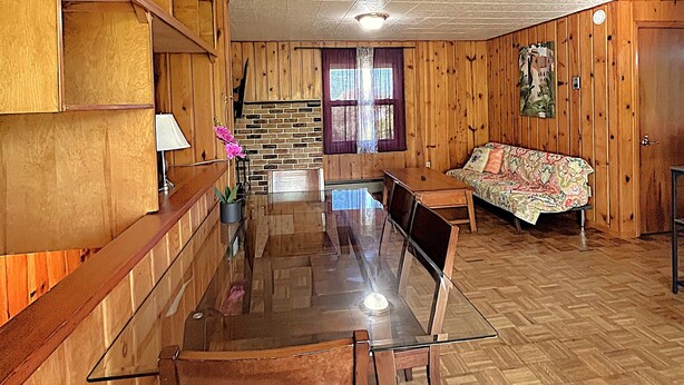 A wooden-paneled room with a dining table, chairs, a sofa, and a window with curtains. - 2-bedroom studio with Fast WiFi in Lynnwood

















 (Lynnwood)