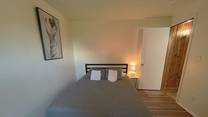 A bedroom with a bed, a bedside lamp, and a door leading to another room. - 2-bedroom studio with Fast WiFi in Lynnwood

















 (Lynnwood)