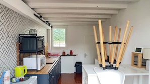 Eine kompakte Küche mit Kochinsel, weißen Schränken und einer Rückwand mit Fischgrätmuster.