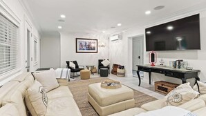 A living room with a sofa set, a coffee table, a TV, and a fireplace. - Battery Place (Savannah)
