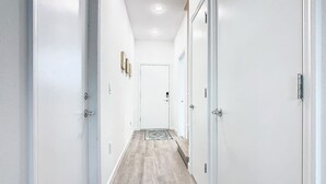 A hallway with white walls and wooden flooring leading to a door at the end. - Spacious 3BR+Den with Hot Tub,  Near Disney! (Davenport)