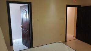 Una habitació amb un llit, una porta i un interruptor a la paret.