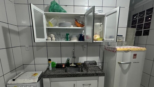 A compact kitchen with a built-in sink, a small oven, and a refrigerator. - Apartamento Privê do Atlântico Salinas (Salinópolis)