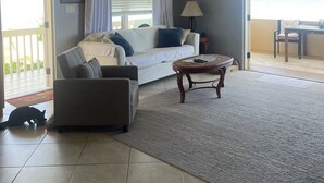 Una sala de estar con sofá, mesa de centro y vistas al exterior.
