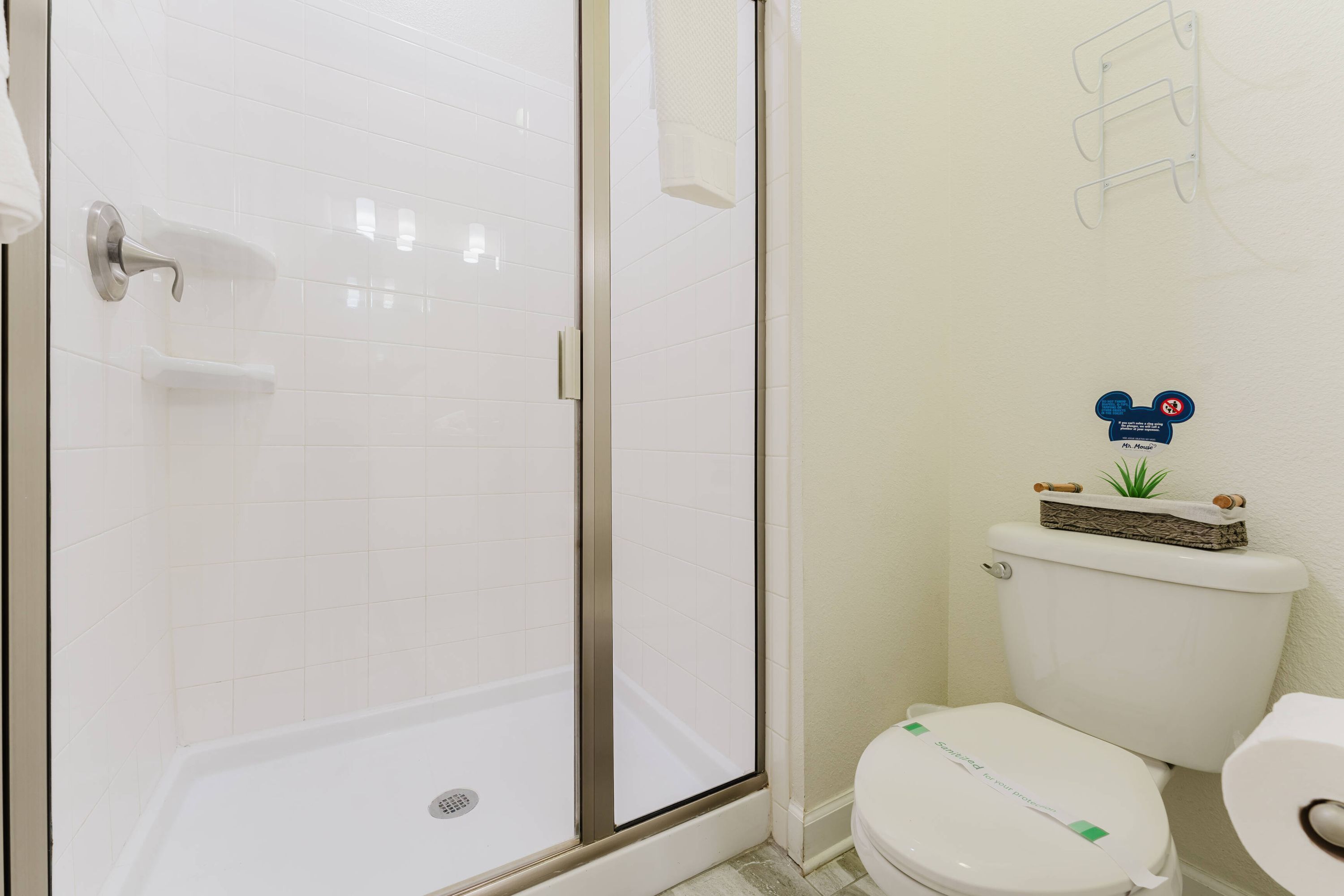 Une salle de bain dotée d’une douche à parois de verre, de toilettes et d’un porte-serviettes fixé au mur.