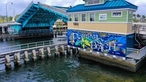 Un bâtiment flottant, doté d’un toit bleu et orné d’une fresque représentant la vie marine.