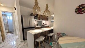 A modern kitchen with a central island, stainless steel appliances, and wooden cabinetry. - 2be 2ba, Playa del Carmen. Ground floor. Free early check in and late check out. (Playa del Carmen)