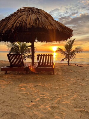 On the beach, white sand, sun loungers, beach umbrellas