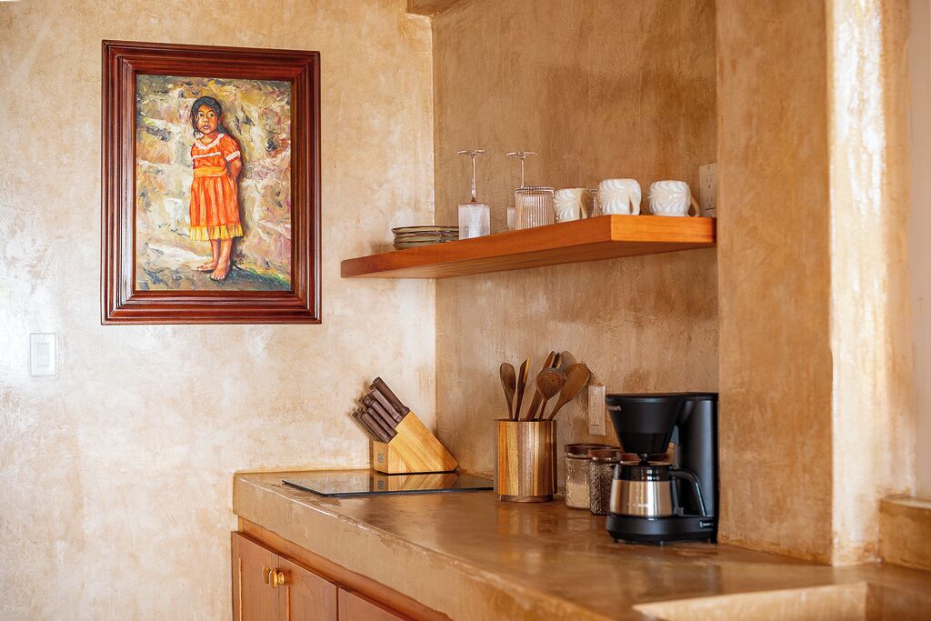 A kitchen with a wooden countertop, a coffee maker, and a knife block.