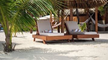On the beach, white sand, sun loungers, beach umbrellas
