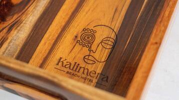 Una bandeja de madera con dos vasos y un logotipo que dice "Kalimera Beach Hotel".