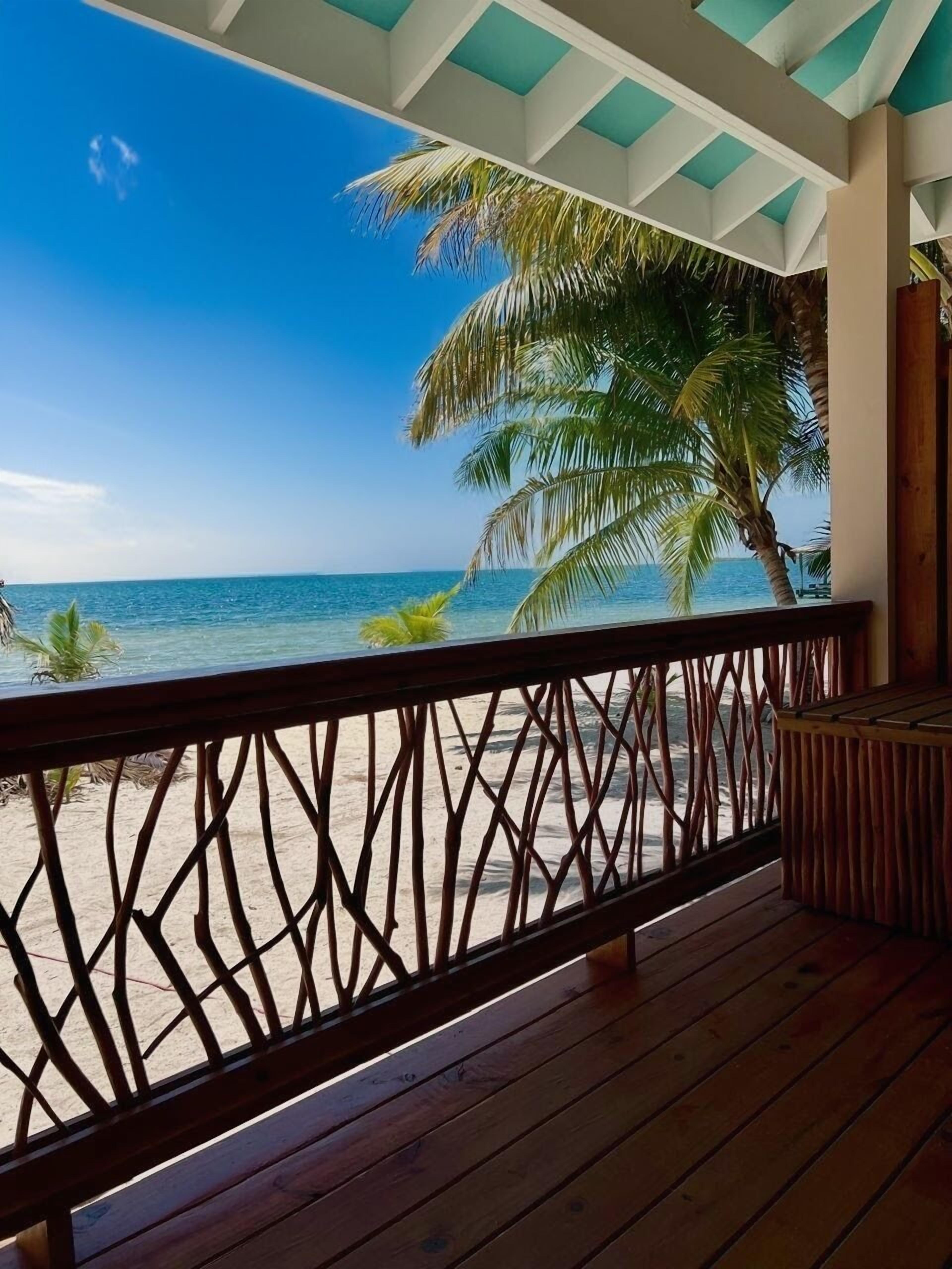 A wooden deck with a view of the beach and ocean.