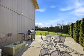 An outdoor patio with a grill, chairs, and an air conditioning unit. - Central Location D in Cul de Sac, 2 Bedroom, 1 Bath-sleeps 6, pets allowed (Kennewick)