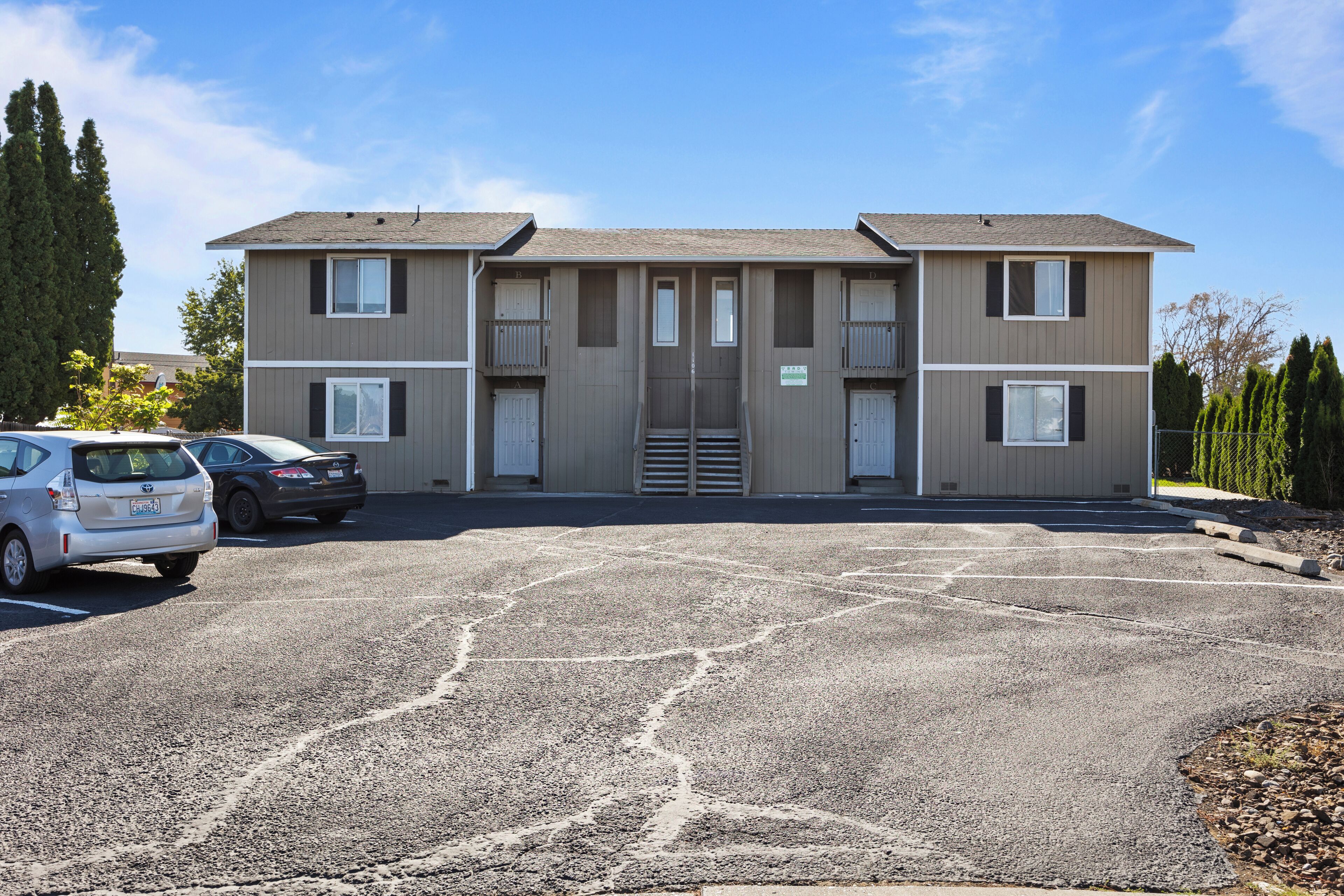 A two-story building with a parking lot in front.
