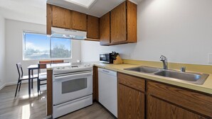 A modern kitchen with wooden cabinets, a stainless steel sink, and a built-in oven.