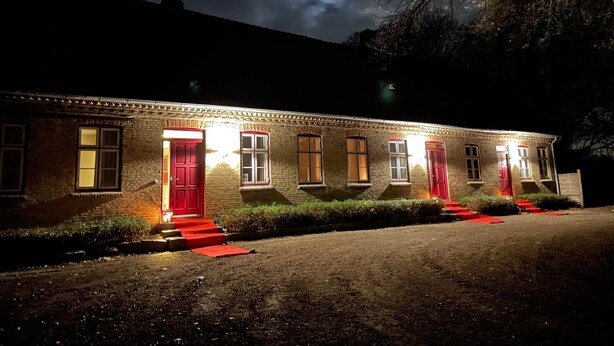 A two-story building with a brick facade, multiple windows, and a red door. - Svaleholm Gaard Roskilde -  Self check - in (Roskilde)