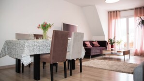 Un comedor con una mesa dispuesta para cuatro personas, un sofá y una mesa de centro.