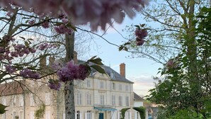 A large stone building with multiple windows and a blue awning in front. - Chateau de Bellefontaine (Flagy)