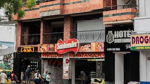 A multi-story building with a brick facade, balconies, and various storefronts including a hotel and a restaurant. - Hotel Santander Plaza (Neiva)