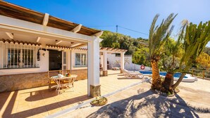 Ein Haus mit Terrasse, Pool und einem Garten mit Kakteen.