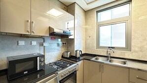 Une cuisine moderne équipée d’un four à micro-ondes, d’une cuisinière et d’un évier.