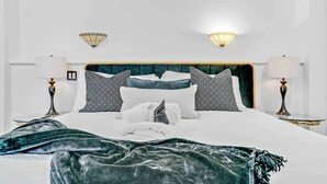 Un dormitorio moderno con una cama grande, dos lámparas de noche y un diseño de cabecera original.