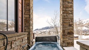 A stone-walled hot tub with a view of snow-covered mountains. - Courcheval Chalet in Mt Village Core with use of 2 free ski passes during stay! (Mountain Village)