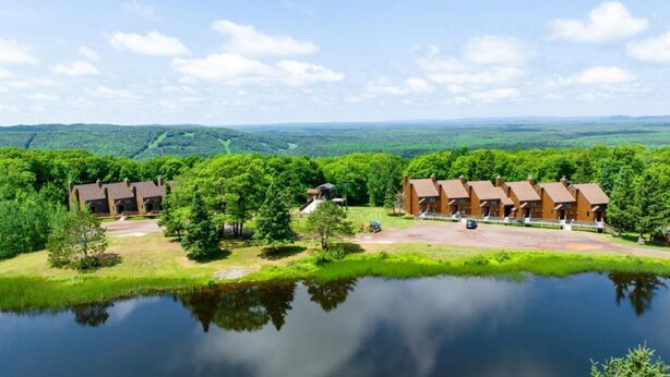 A lakeside lodge with multiple cabins, a central building, and a view of the surrounding forest. - Ski in/Ski Out Entire Condo Sleeps 4 @ Jackson Creek Summit (Wakefield)