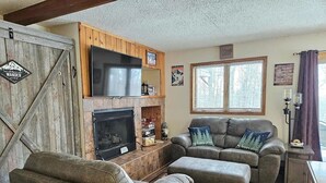 A cozy living room with a fireplace, leather sofas, and a TV. - Ski in/Ski Out Entire Condo Sleeps 4 @ Jackson Creek Summit (Wakefield)