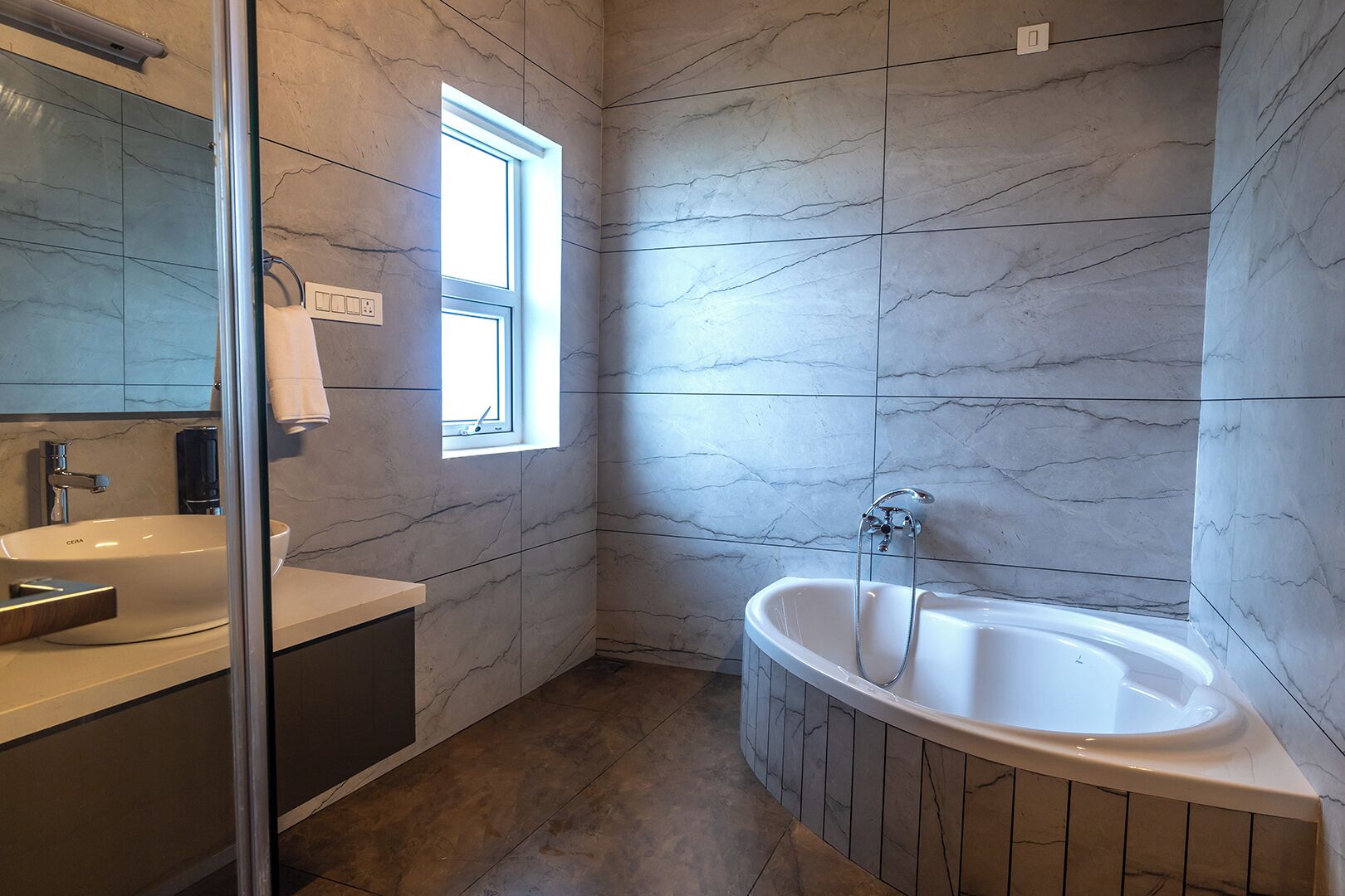 A modern bathroom with a large bathtub, a glass-enclosed shower, and a vanity with a sink.