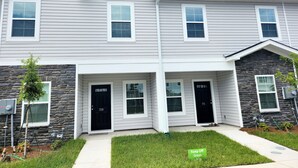 A two-story townhouse with a stone facade, multiple windows, and a front door labeled "709". - Newly Built Getaway! (Columbia)