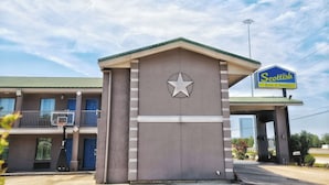 A motel with a star logo, a basketball hoop, and a sign for 'Scottish Inns & Suites'. - Scottish Inns & Suites Shenandoah Woodlands Mall (Shenandoah)