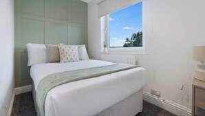 A bedroom with a bed, a window, a radiator, and a bedside table. - 3BR in County Durham with WiFi and Street Parking (Ludworth)