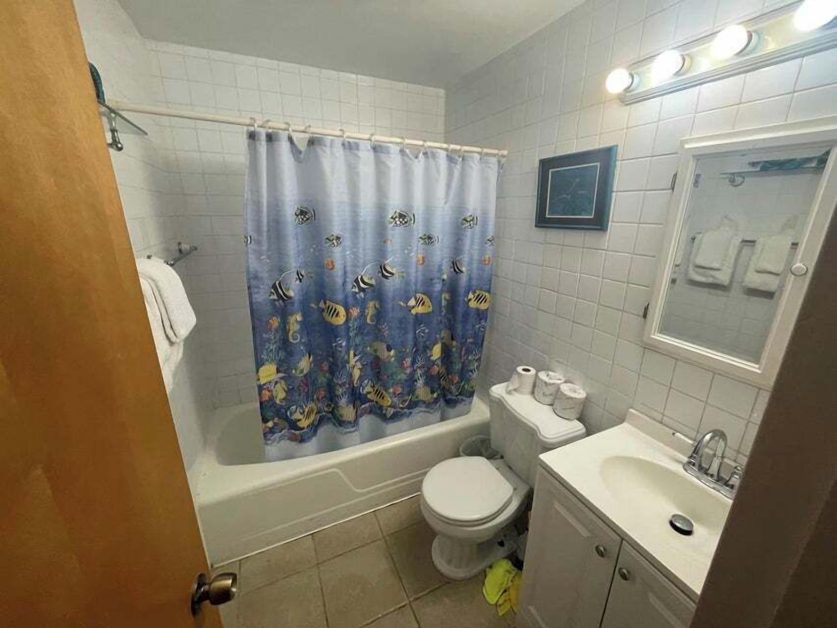 A bathroom with a bathtub, toilet, and sink.