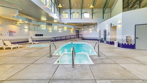 An indoor swimming pool with lounge chairs, a staircase, and a view of the sky through large windows. - Mtn-View Condo w/ Community Perks in Silverthorne (Silverthorne)