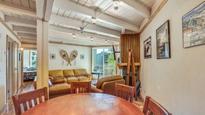 A spacious dining area with a wooden table and chairs, a leather sofa, and a large window providing natural light. - Mtn-View Condo w/ Community Perks in Silverthorne (Silverthorne)